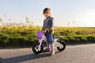 Kind sitzt auf einem pinken Laufrad