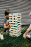 Zwei Kinder spielen mit XXL-Wackelturm im Garten